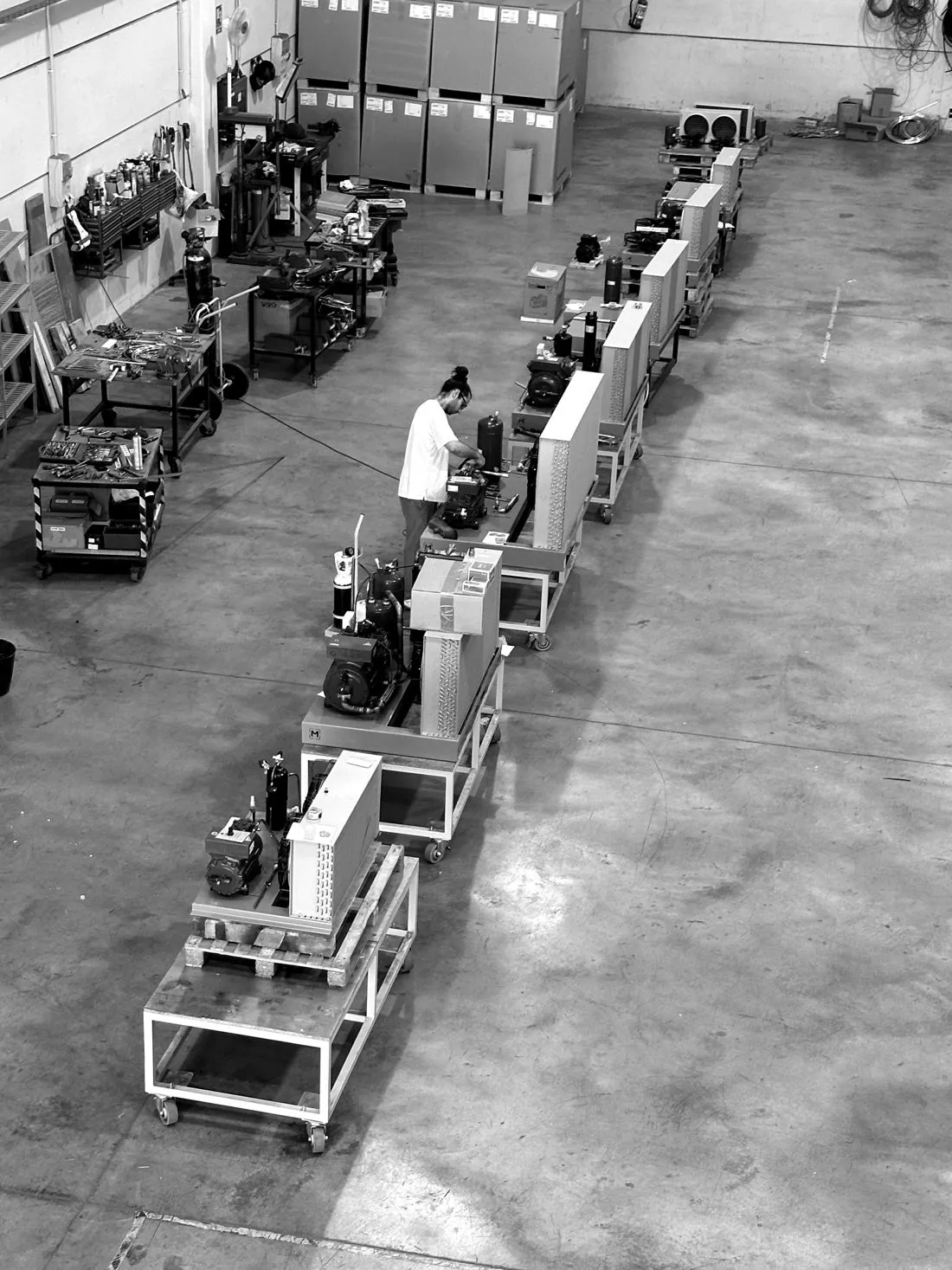 Línea de montaje de unidades condensadoras en la nave de Paterna, vista desde arriba, con un técnico trabajando